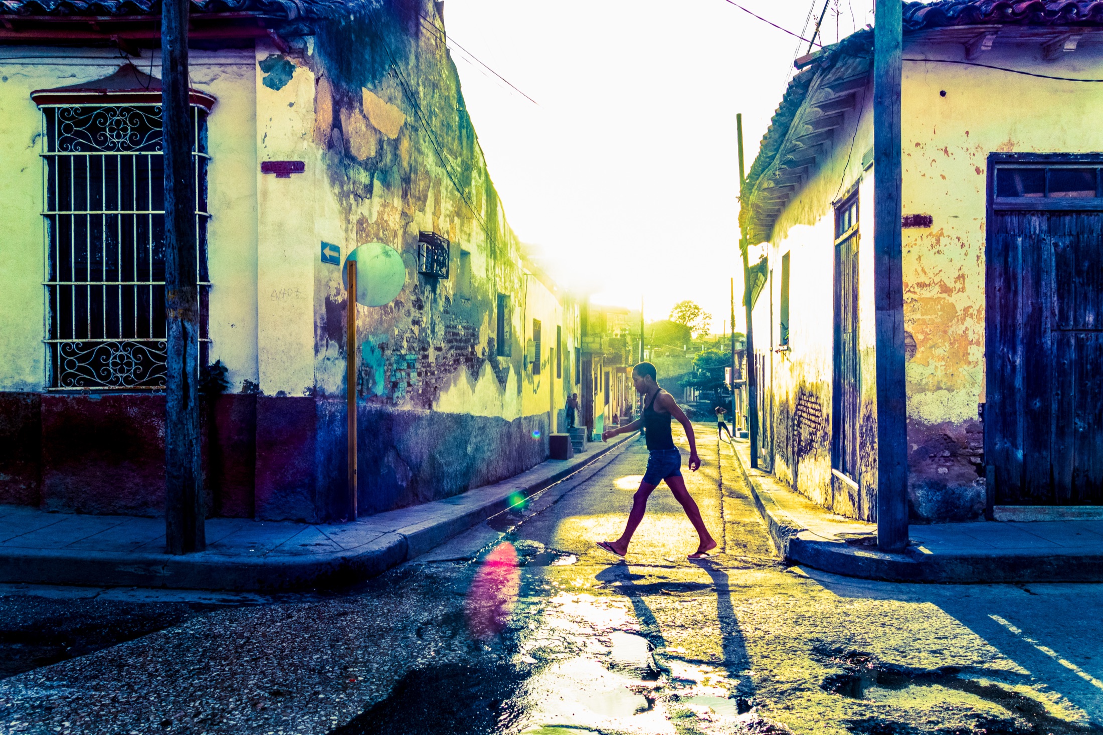 Person walking on a golden-lit street in Havana